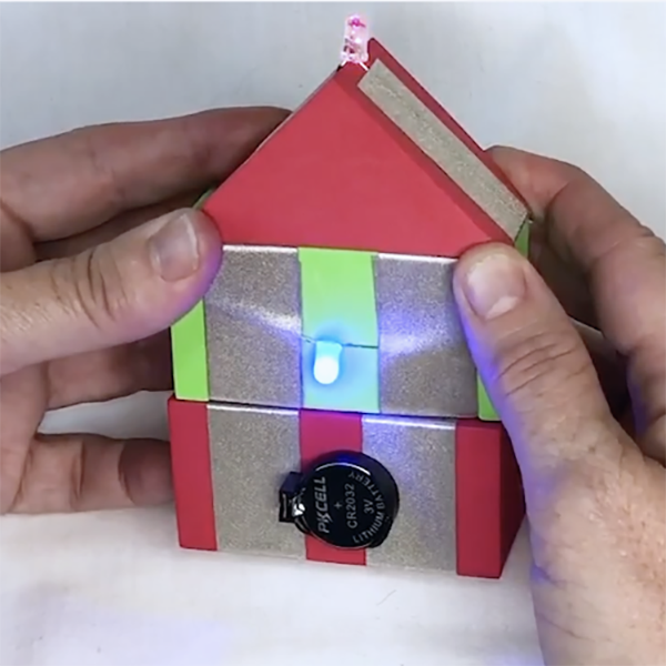 TapeBlocks that look like a house. A red power TapeBlock at the bottom, a green TapeBlock in the middle with a light, a red triangle roof TapeBlock with a pink light at the top. 