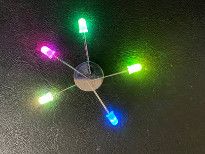 5 LEDs around a 3V button cell battery, pink, green, yellow, blue, white