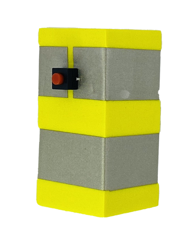 A yellow foam block with two parallel rows of conductive tape wrapped around it. The top layer of tape has a gap in it and in the gap is a red button in a black switch. 