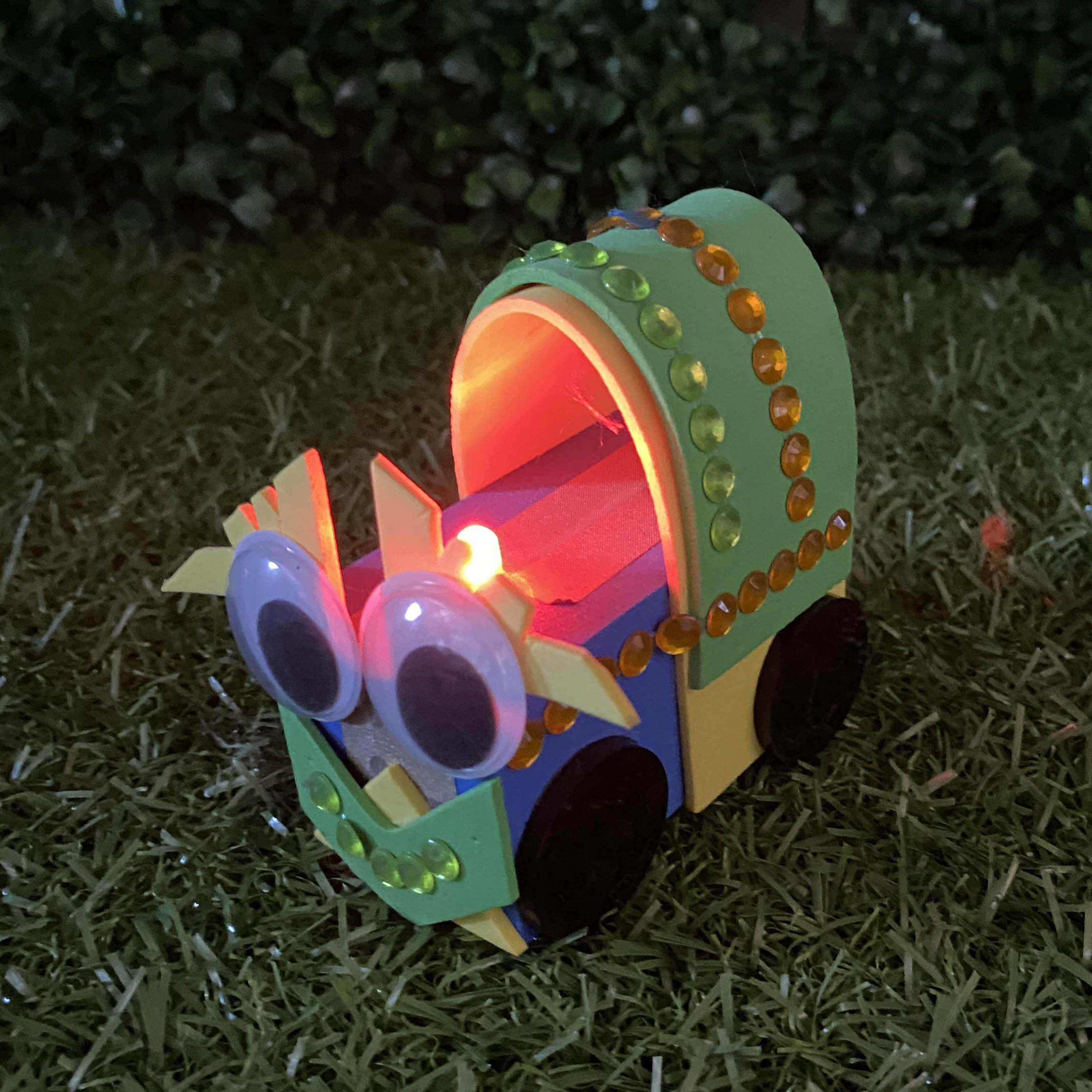 TapeBlock Train with black and white eyes and red light up funnel, It is sitting on the grass