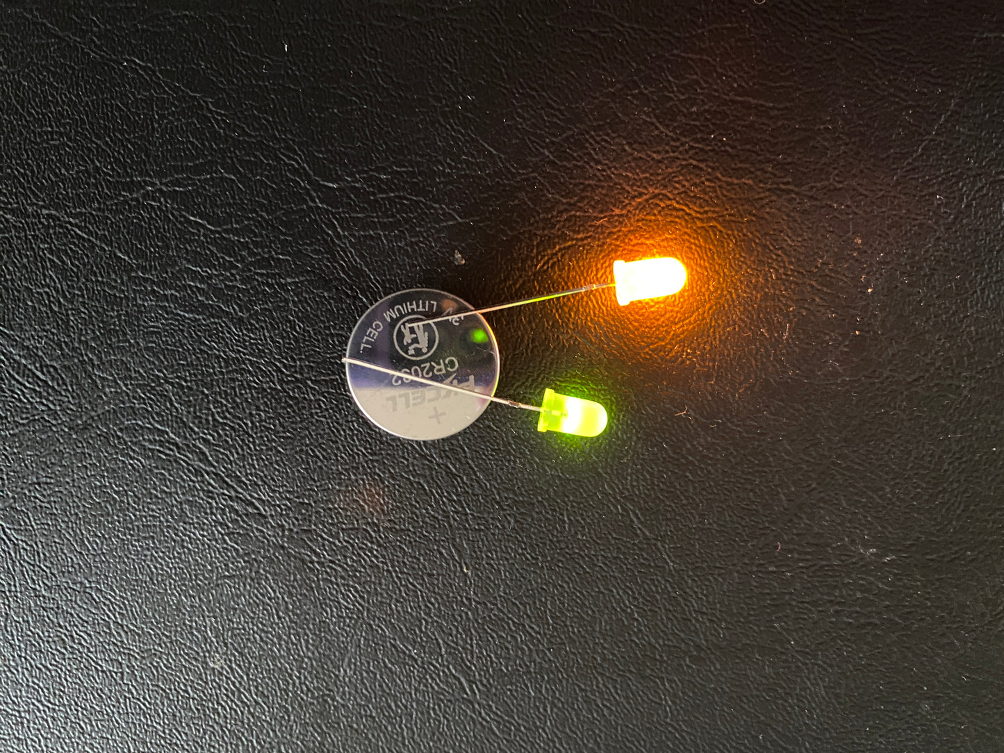 Yellow and green 5mm LEDs on a 3V battery, the legs are different lengths