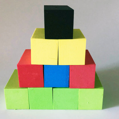 A pyramid of colorful foam blocks, Layer 1 - 4 green, Layer 2 - red, blue and red, Layer 3 - 2 yellow and then Layer 4 - black on top