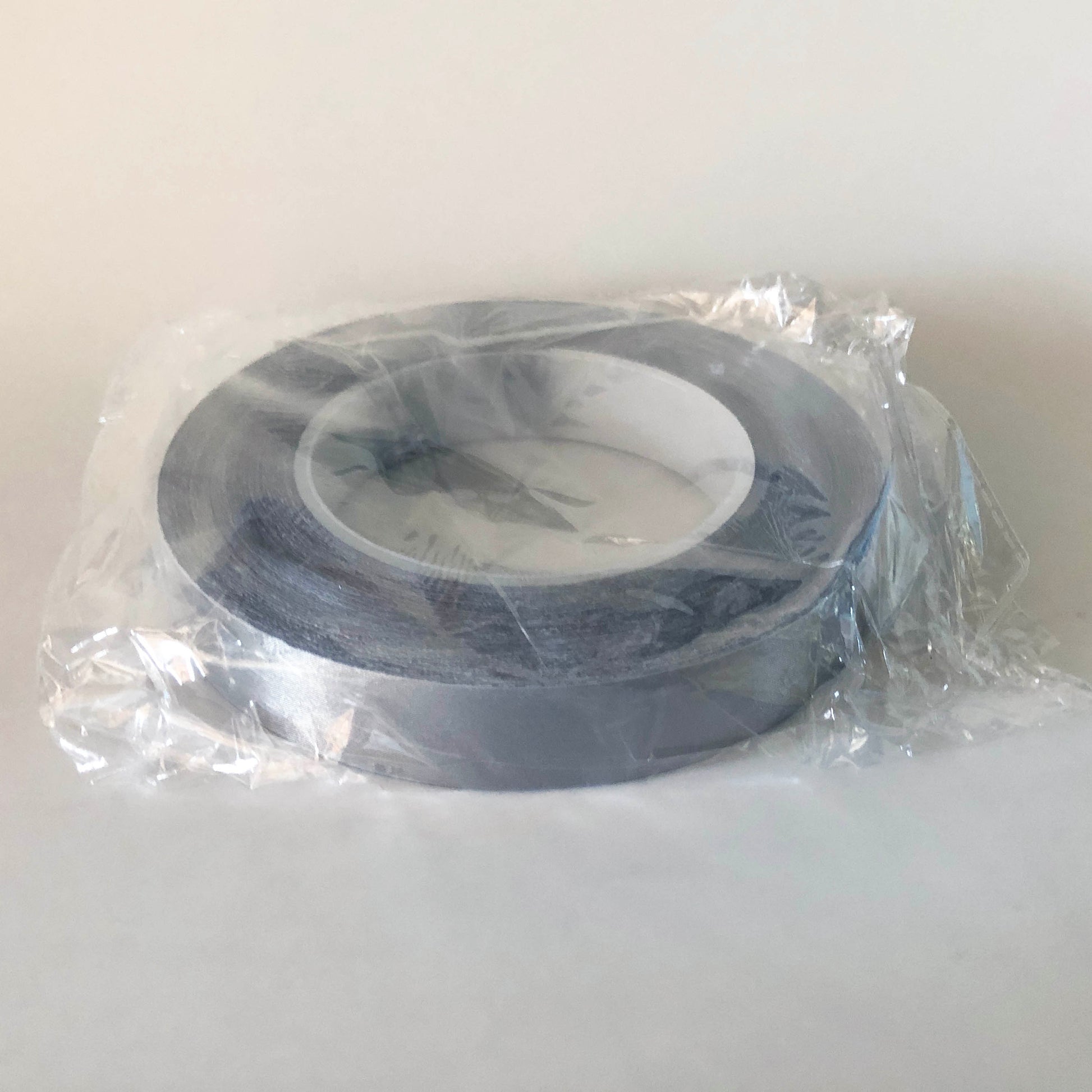 A roll of conductive tape in a bag. The core of the roll is 7cm and the tape is 2cm wide. 
