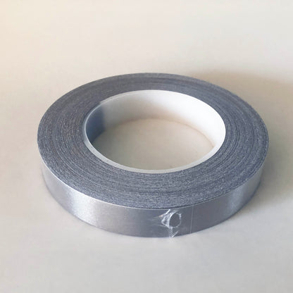 A roll of conductive tape in a plastic shrink wrap, The core of the roll is 7cm and the tape is 2cm wide